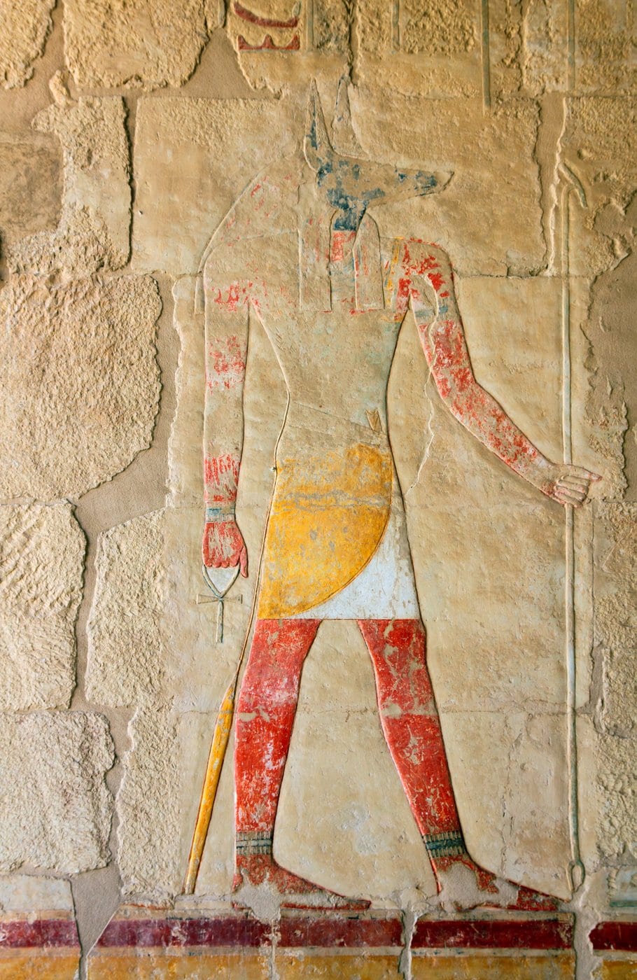 Ancient image of the Egyptian god Anubis carved into a wall in Luxor