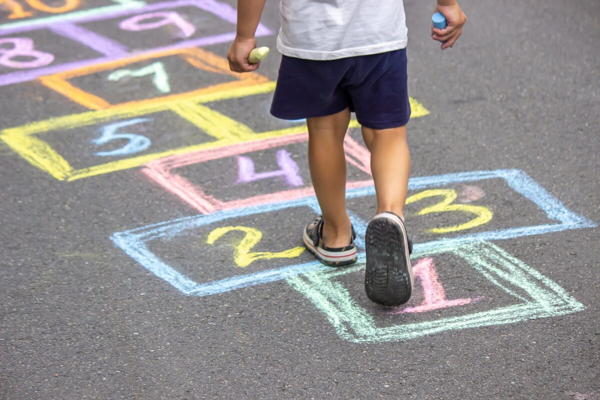Child playing hopscotch in the street