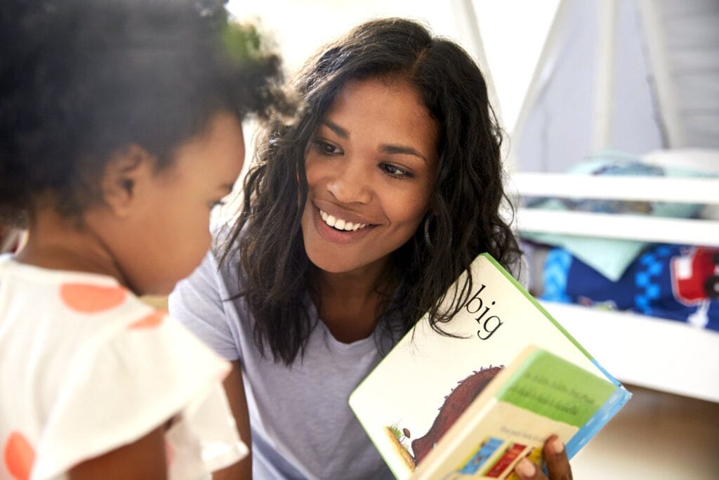 Mother and toddler daughter reading a baby board book