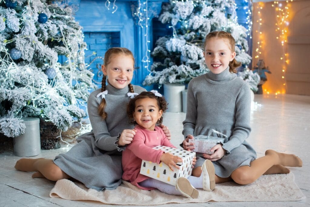 Three girls with Christmas trees and presents - Avoid holiday tantrums